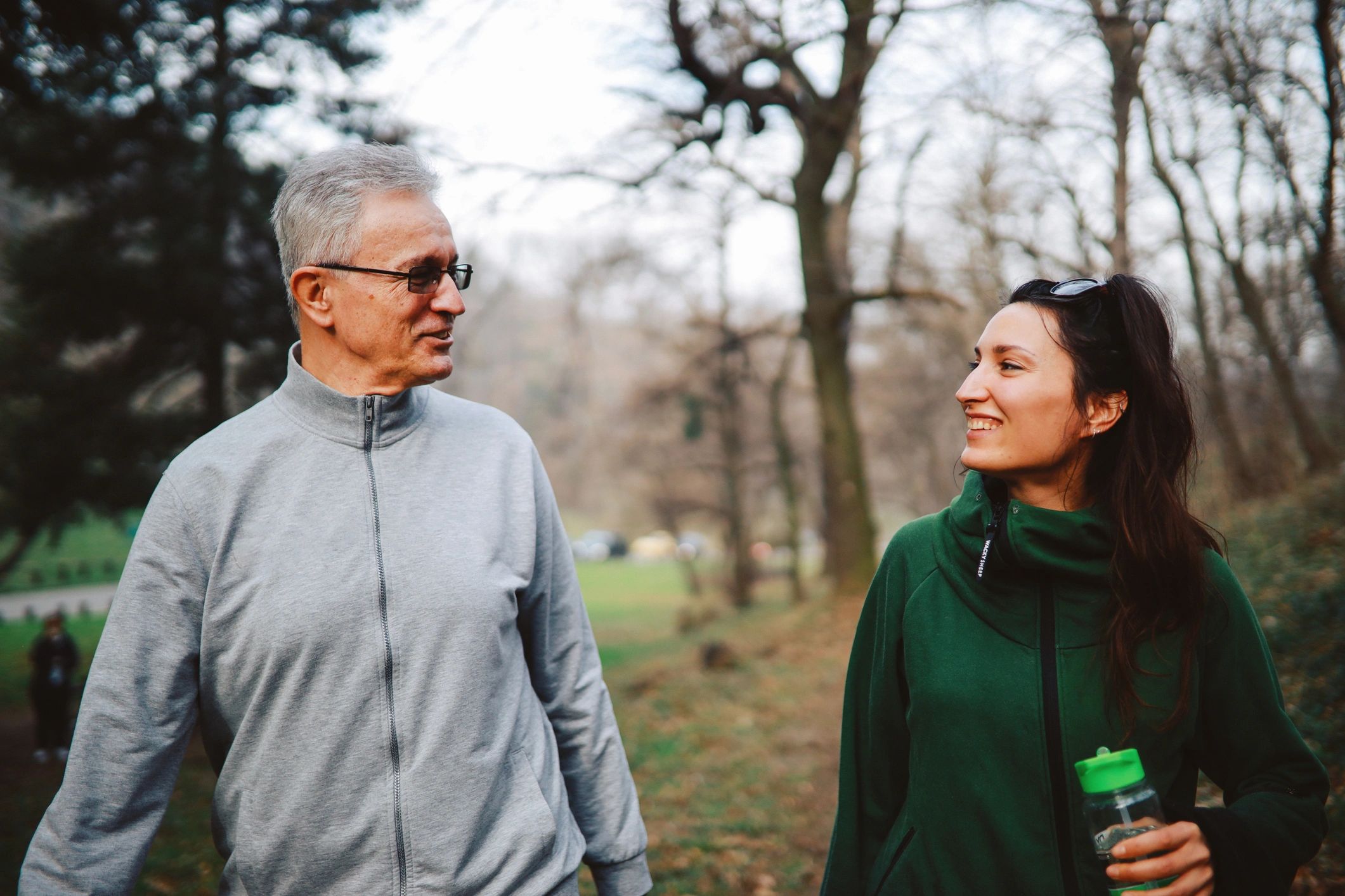 Older adult and family member walking outdoors together for wellness and connection