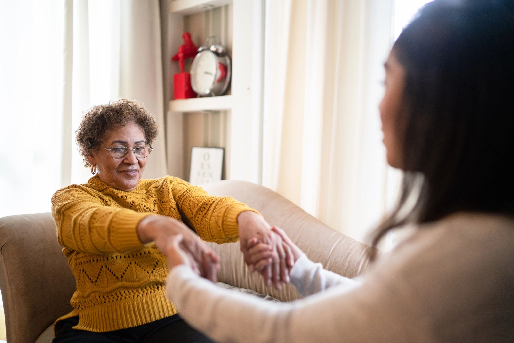 Care professional assisting a senior with gentle exercise at home