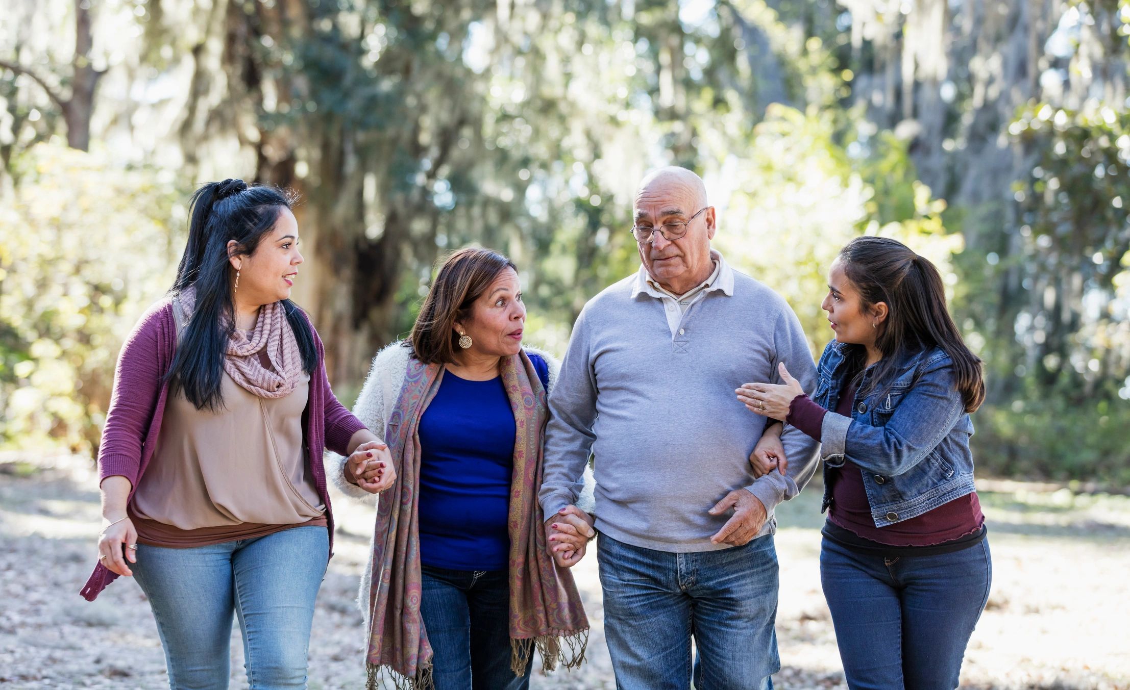 Senior couple walking with adult daughters at a park