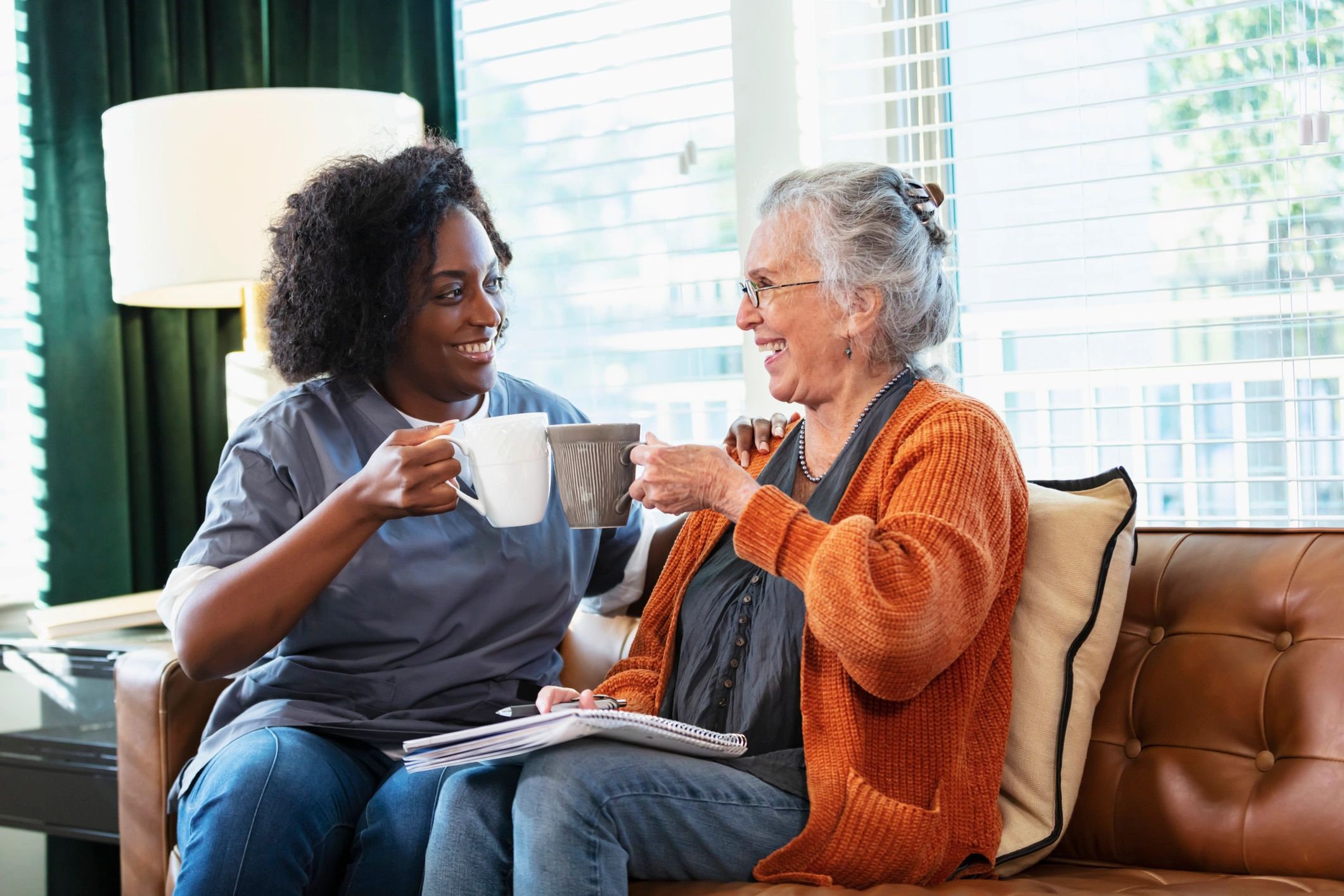 Senior woman having coffee with a home caregiver
