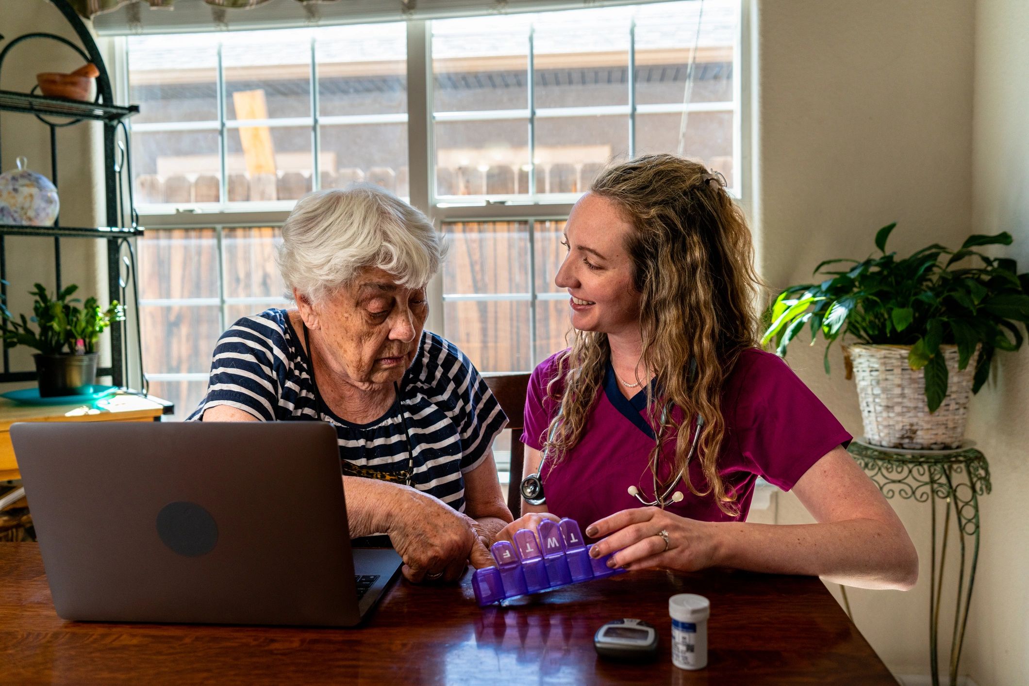 Caregiver discussing medications with an older adult at home