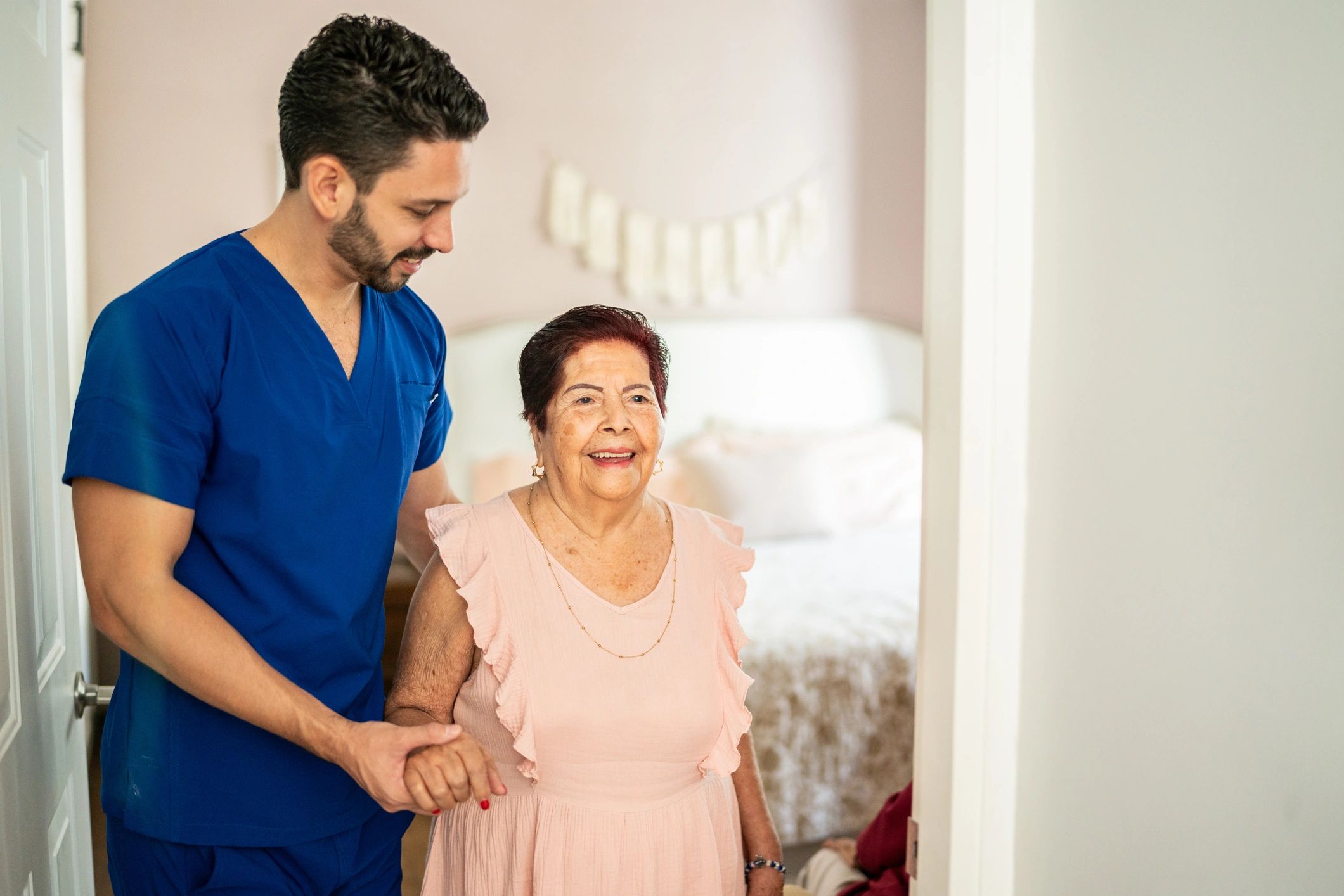 Home caregiver helping an older woman walk safely at home