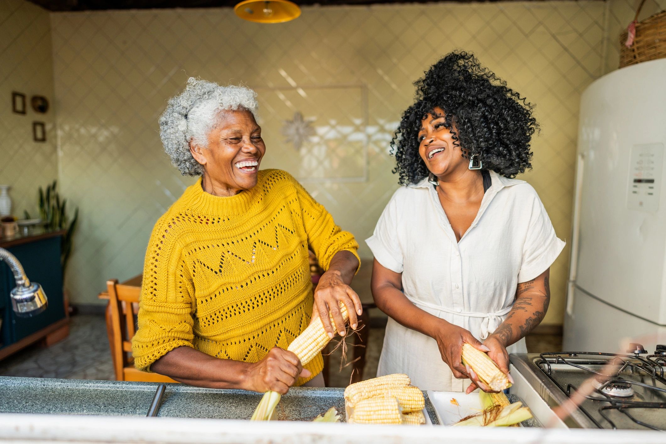 Mother and adult daughter cooking together at home