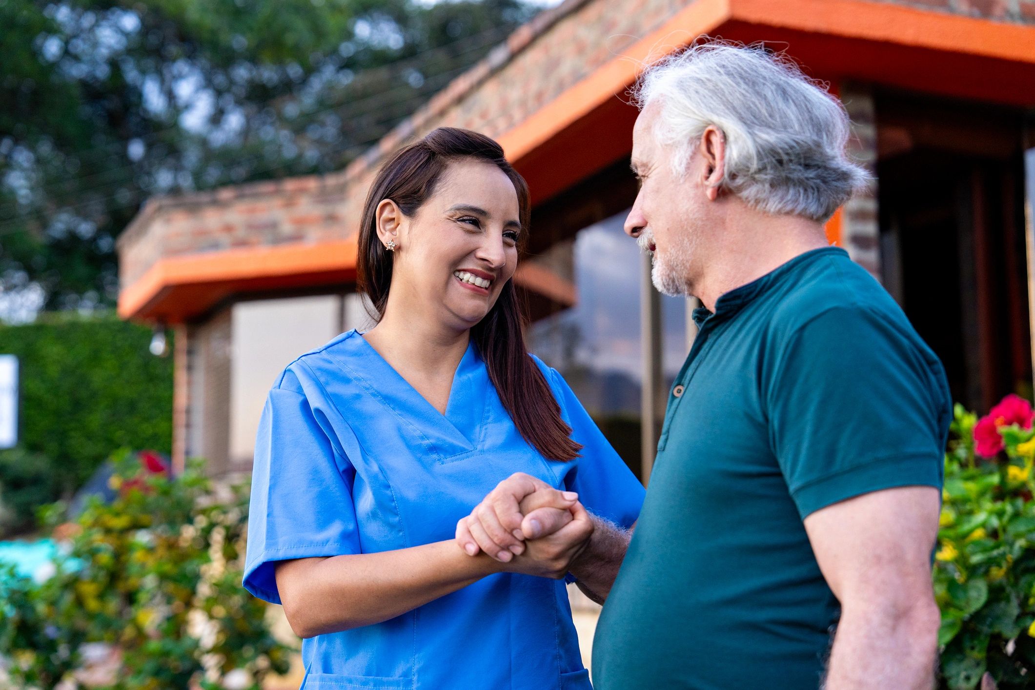 Caregiver smiling with an older adult at home